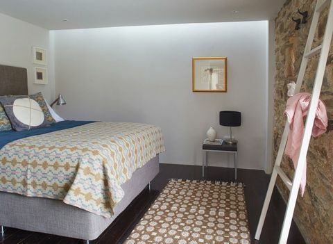 Претворена камена амбар са две спаваће собе, у близини села Инистиоге у округу Килкенни. Спаваћа соба доле: Дрвени под је обојен упечатљивом тамном бојом која је била у контрасту са бледим зидовима и намештајем