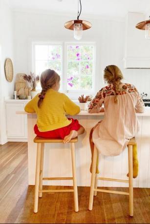 две девојке раде домаћи задатак на кухињском острву