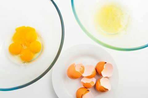 Јаје и жуманца у засебној стакленој посуди. Јаја и јаје на белом тањиру.