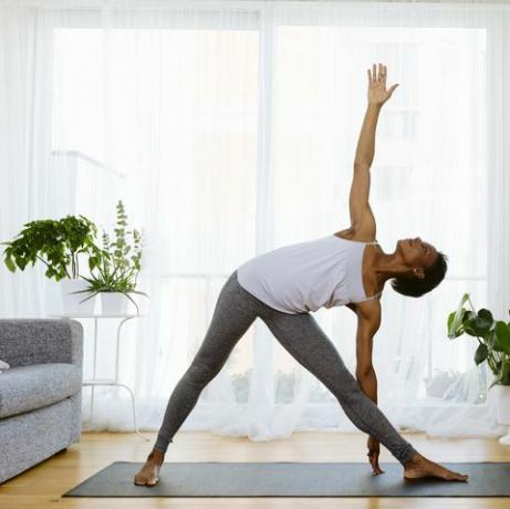 Жена која практикује јогу код куће