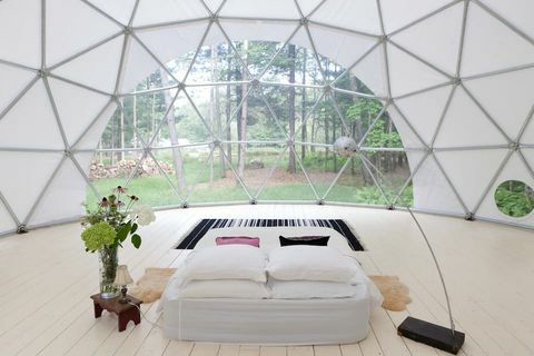 унутрашњост гео куполе са креветом и лампом у центру