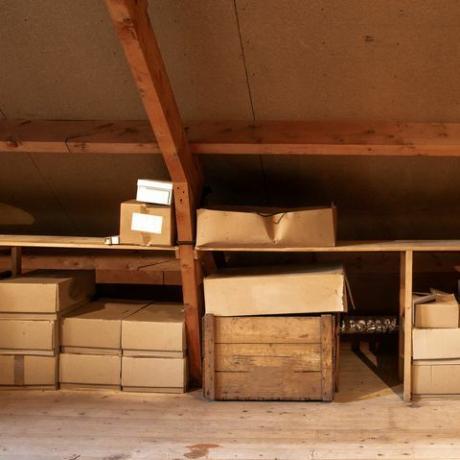 стари дрвени ентеријер поткровља са старим картонским кутијама за складиштење или селидбу, изблиза
