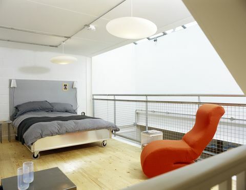 Модерна спаваћа соба са сивим покривачем и јарко наранџастом столицом